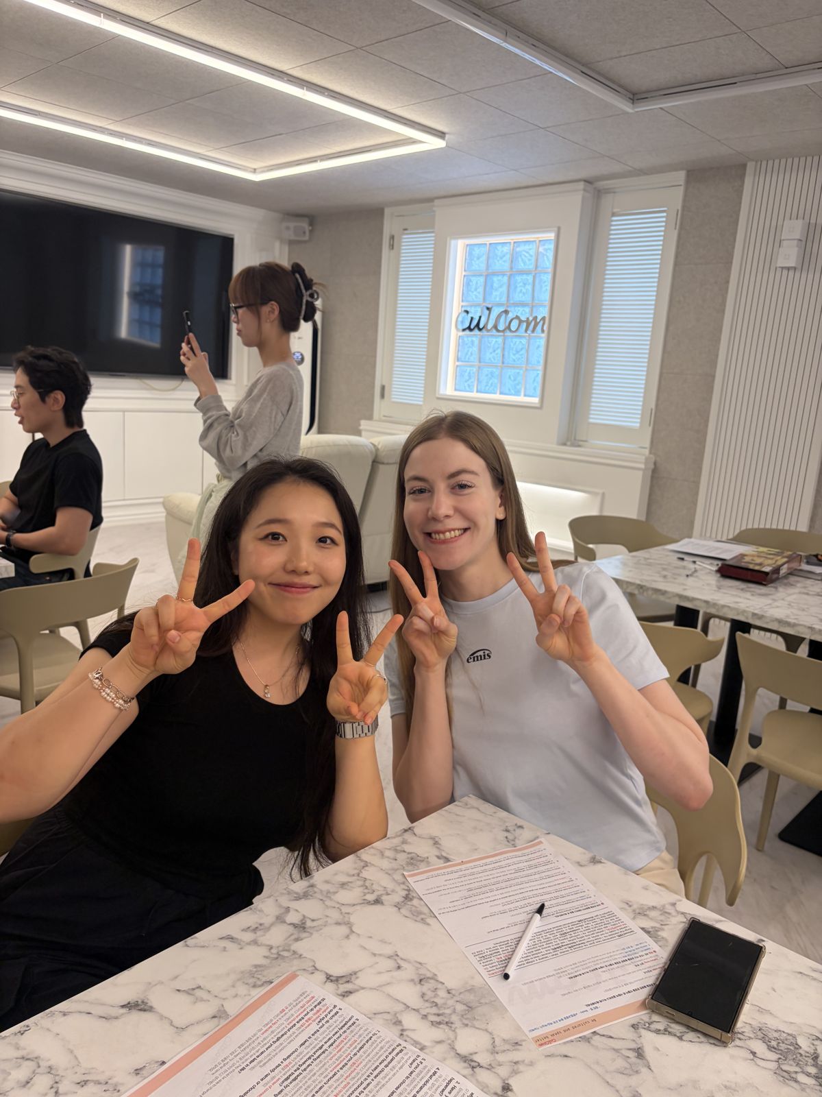 스터디 테이블에서 브이를 하는 회원 두 명