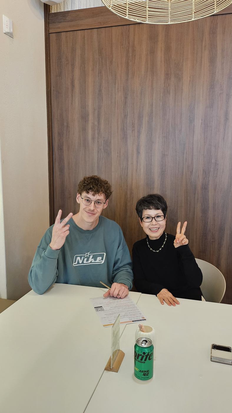 원어민 친구와 나란히 앉아 브이를 하는 회원